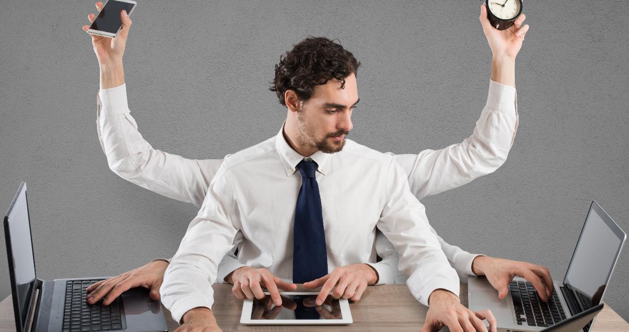 A person using several devices at the same time to represent multi-tasking